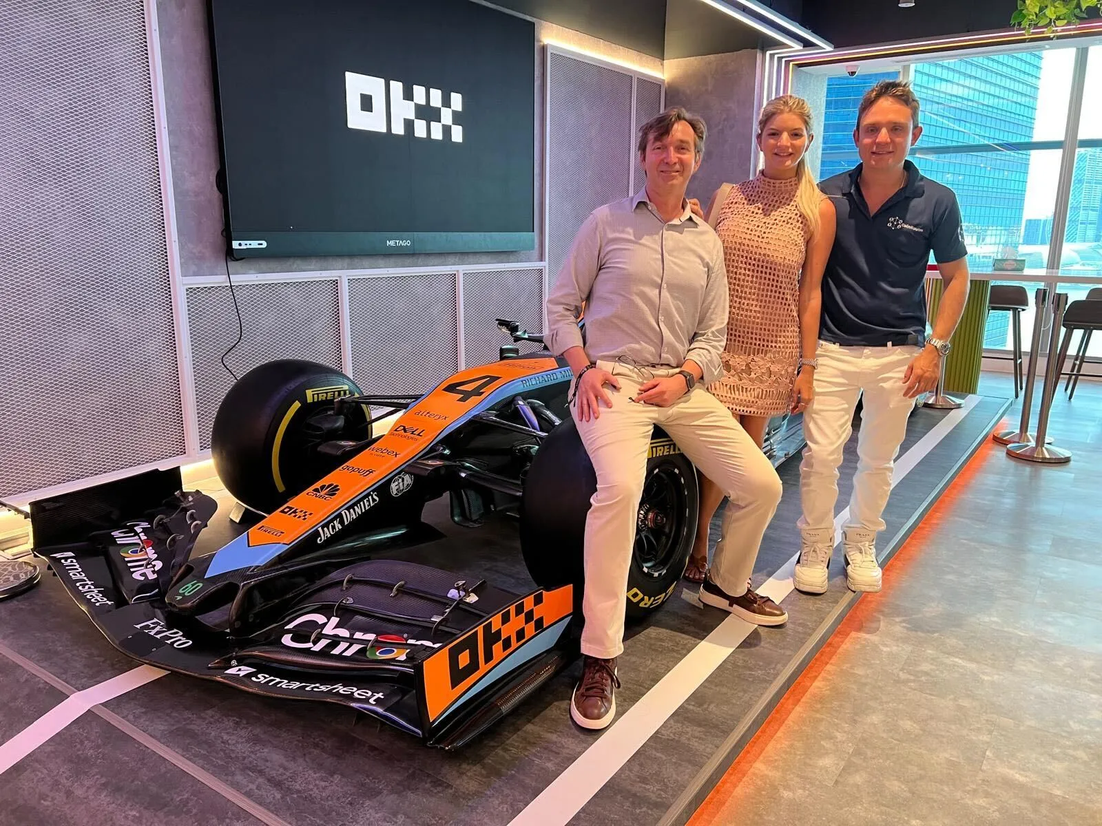 Michael and teammates posing with a McLaren F1 car at OKX event